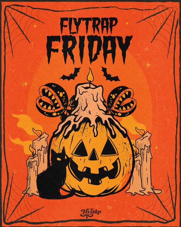 A jack-o-lantern surrounded by candles and Venus flytraps with a black cat.